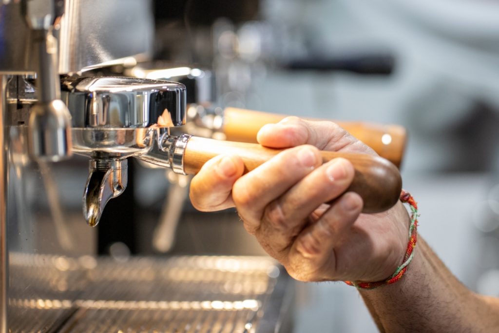 detalle de una mano con un portafiltros en una máquina La Rocca apra contar la historia de Fernando.